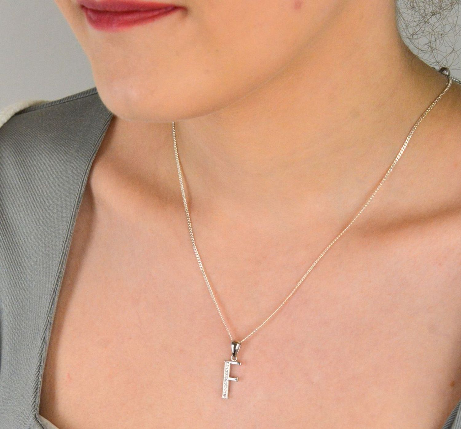 Zawieszka literka F z cyrkoniami próba 925, AP17-0213 F Zawieszka w kształcie literki „F” ozdobiona cyrkoniami to elegancka i subtelna biżuteria wykonana z wysokiej jakości srebra próby 925. 1.jpg